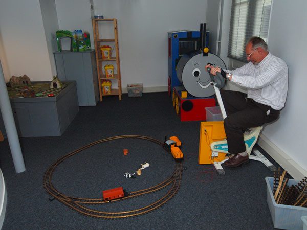Museummanager Tjeerd Cramer demonstreert een modelspoor waarmee kinderen kunnen spelen.