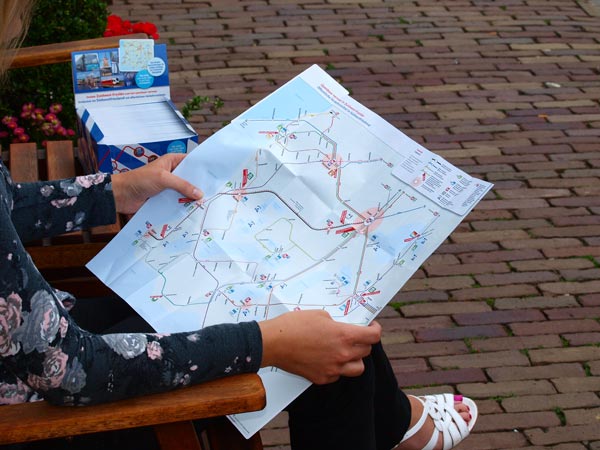 Alinde Holsappel, touroperator bij Friesland Holland, toont de nieuwe OV-toeristenkaart.