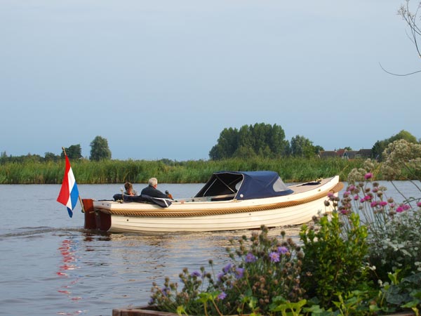 Met de sloep door Friesland, een veelgeboekte vakantie van Friesland Holland Travel. De foto werd gemaakt vanaf het terras van hotel-restaurant Ie-sicht in Oudega (Smallingerland).