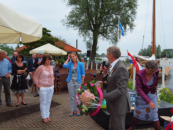 Jack van den Berg had bloemen meegenomen voor zijn medewerkers, Ilse Veenstra (in roze blouse) en Sascha den Herder (in KLM-blauw colbert). De secretaresses zijn volgens hem net zulke fanatieke Marrekriters als hij. Links achter Ilse staat Lia Kolk uit Franeker. Zij overlaadde Van den Berg namens de zestig vrijwilligers van het recreatieschap met nuttige cadeautjes aan boord.