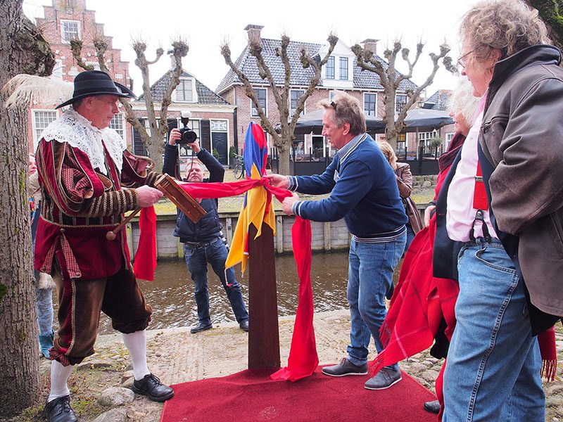 Pietsje wordt ontdaan van de stadsvlag van Sloten door Pieter Haringsma en Bavo Galama onder toeziend oog van kunstenaar Evert van Hemert (geheel rechts).