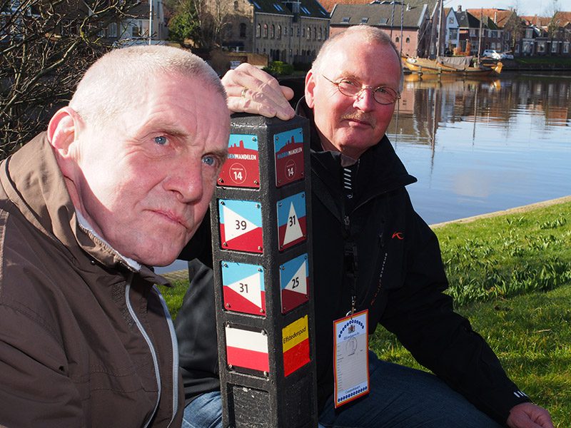 Johan Vellinga (links) en zijn “supporter” Tjisse Brookman, voorzitter Koninklijke Wandel Bond Nederland, regio Fryslân, bij knooppunt Dokkum.