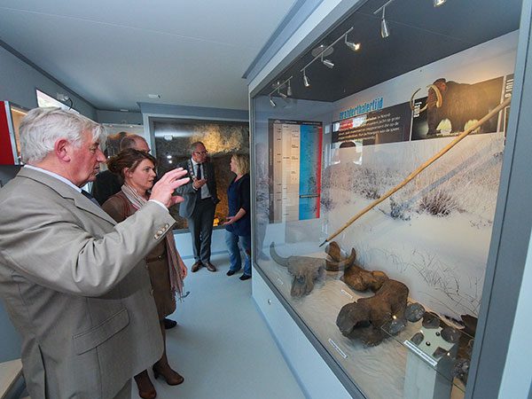 Jan Kloosterman leidt gedeputeerde Jannewietske de Vries langs de vitrines over het Midden-paleolithicum in het nieuwe deel van het IJstijdenmuseum. Dit deel van de permanente expositie gaat over de Friese Wouden van 300.000 jaar geleden tot 35.000 jaar geleden, het tijdvak van de Neanderthaler.