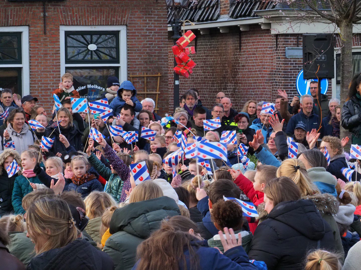 Plein met kinderen met Friese vlaggen